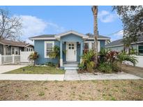 Charming blue house with white door, landscaping, and walkway at 8907 N Boulevard, Tampa, FL 33604