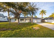 Ranch-style home with mature landscaping, attached garage, and spacious yard at 608 Florida Blvd, Crystal Beach, FL 34681