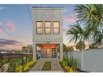 Modern two-story house with gray siding, paved driveway, and landscaping at 108 E Chelsea St, Tampa, FL 33603