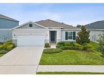 Single-story house with a two-car garage and landscaped lawn at 12772 Achasta Blvd, Hudson, FL 34669