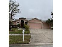 One-story house with two-car garage, landscaped yard, and a neutral color palette at 16201 Muirfield Dr, Odessa, FL 33556