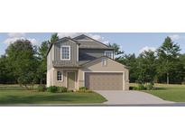 Two-story house with gray and beige siding, two-car garage, and landscaping at 17638 Happytrails St, Land O Lakes, FL 34638