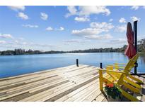 Serene waterfront dock with yellow chairs, offering picturesque lake views at 18803 15Th St, Lutz, FL 33549