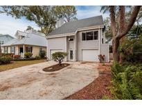 Two-story house with gray siding, two-car garage, and a landscaped front yard at 407 Bay View St, Safety Harbor, FL 34695