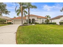 Single-story home with tile roof, palm trees, and a well-manicured lawn at 4339 Cheval Blvd, Lutz, FL 33558