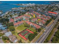 Wide aerial shot of condo community with red roofs, a community pool, and Gulf access at 2353 Hanover Dr, Dunedin, FL 34698