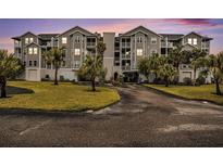 Three-story condo building with lush landscaping and ample parking at 5727 Biscayne Ct # 305, New Port Richey, FL 34652