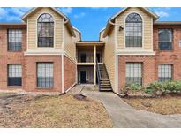 Attractive two-story condo building with brick and siding exterior, stairs, and landscaping at 8647 Fancy Finch Dr # 203, Tampa, FL 33614