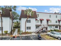 Two-story condo building with a brown roof and white exterior at 9119 Tudor Dr # E201, Tampa, FL 33615