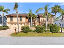 Two-story house with a double garage and palm trees at 127 6Th E St, Tierra Verde, FL 33715