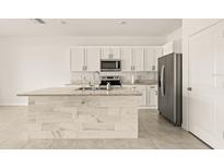 Modern kitchen with white cabinets, granite countertops, and island at 34395 Sorrel Mint Dr, Wesley Chapel, FL 33543