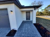 Modern house exterior with gray paver walkway leading to front door and attached garage at 4743 Michaler St, North Port, FL 34286