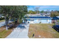 Aerial view of a single-story home with solar panels and a spacious driveway at 5481 65Th N Ave, Pinellas Park, FL 33781
