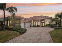 Beautiful home with tile roof, three car garage, and a brick paved driveway at 10553 Bermuda Isle Dr, Tampa, FL 33647