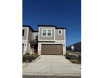 Two-story townhome with brown garage door and gray exterior at 10812 Fanning Springs Ct, Tampa, FL 33647