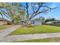 Ranch style home with carport and mature landscaping at 1434 Longwood Loop, Tampa, FL 33619