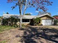 Charming single-story home with mature landscaping, a well-manicured yard, and an attached garage at 1700 Kay Dr, Largo, FL 33770