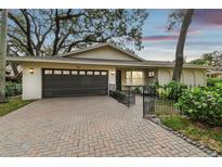 House exterior featuring a dark brown garage door and brick driveway at 356 Grand Central Ave, Safety Harbor, FL 34695