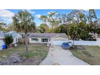 Single-story house with a yard, driveway, and palm trees at 4543 Indianapolis Ne St, St Petersburg, FL 33703