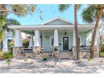 Charming light-green house with a large front porch and stone pillars at 1039 10Th N St, St Petersburg, FL 33705