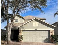 Two-story house with a neutral exterior, two-car garage, and landscaping at 1348 Impatiens Ct, Trinity, FL 34655