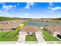 Aerial view of two-story home with lake access in a new community at 18058 Turning Leaf Cir, Land O Lakes, FL 34638