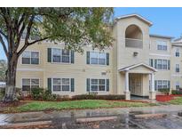 Condo building exterior featuring light-yellow siding, dark-green trim, and a well-maintained entrance at 18402 Bridle Club Dr # 18402, Tampa, FL 33647