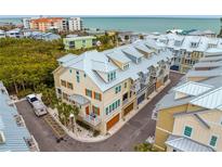 Aerial view of townhouses near the beach with metal roofs and balconies at 19915 Gulf Blvd # 303, Indian Shores, FL 33785