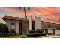 Two-story condo building with palm trees and sunset sky at 2750 E Bay Dr # 1E, Largo, FL 33771