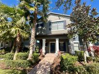 Two-story house with a blue door and landscaped yard at 28489 Tranquil Lake Cir, Wesley Chapel, FL 33543