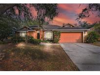 Single-story house with orange siding, attached garage, and landscaping at 4020 Concord Way, Plant City, FL 33566
