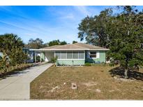 Charming ranch home with a light green exterior, and a well-maintained lawn at 436 Norfolk St, Dunedin, FL 34698