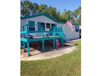 Mobile home with large deck, American flag, and spacious yard at 6274 Boatwrite Rd, Spring Hill, FL 34609