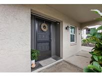 Inviting condo entryway with a wreath and potted plants at 8703 Bardmoor Blvd # 106, Seminole, FL 33777