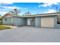 Newly painted light blue home with a 1-car garage, landscaped lawn, and paved driveway at 9100 52Nd N Way, Pinellas Park, FL 33782