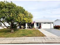 White single story home with carport, landscaped lawn, and mature tree at 9231 41St N St # 5, Pinellas Park, FL 33782