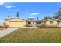 Ranch style home with attached garage and landscaped lawn at 1243 Bayshore Dr, Terra Ceia, FL 34250