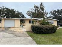 Ranch style home with carport, basketball hoop, and mature landscaping at 1373 Fairfax Rd, Clearwater, FL 33764