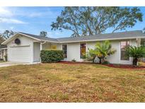 Ranch style home with attached garage and landscaped lawn at 1753 Lucas Dr, Clearwater, FL 33759