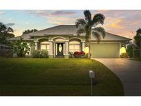 Beautiful one-story home with a lush green lawn and palm trees at 2262 Sagebloom Ter, North Port, FL 34286