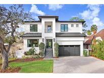 Two-story modern home with white brick exterior, gray metal roof, and landscaped lawn at 2623 S Parkview St, Tampa, FL 33629