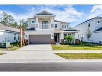 Charming two-story home with a balcony, well-manicured lawn, and a two-car garage at 33945 Landsman Loop, Wesley Chapel, FL 33543