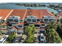 Aerial view of waterfront townhouses with red tile roofs and lush landscaping at 4625 Mirabella Ct, St Pete Beach, FL 33706