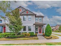 Two-story home with gray siding, red door, and landscaped front yard at 5716 Colony Glen Rd, Lithia, FL 33547