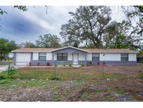 Newly renovated home with a modern exterior, featuring a neutral color palette and landscaping at 1801 E 99Th Ave, Tampa, FL 33612