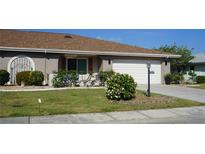 Well-maintained house with a landscaped lawn, attached garage, and attractive curb appeal at 317 Green Manor Dr # 38 B, Sun City Center, FL 33573