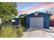 Newly painted blue home with a landscaped yard and attached garage at 3628 Holiday Lake Dr, Holiday, FL 34691