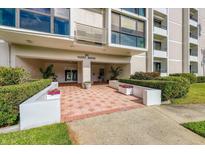 Welcoming entryway to Yacht House, featuring a tiled patio and lush landscaping at 851 Bayway Blvd # 201, Clearwater, FL 33767