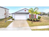 One-story home with white garage door and landscaping at 9805 Lemon Drop Loop, Sun City Center, FL 33573