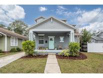 Gray craftsman home with a light teal door, landscaping, and a walkway at 117 W Minnehaha St, Tampa, FL 33604